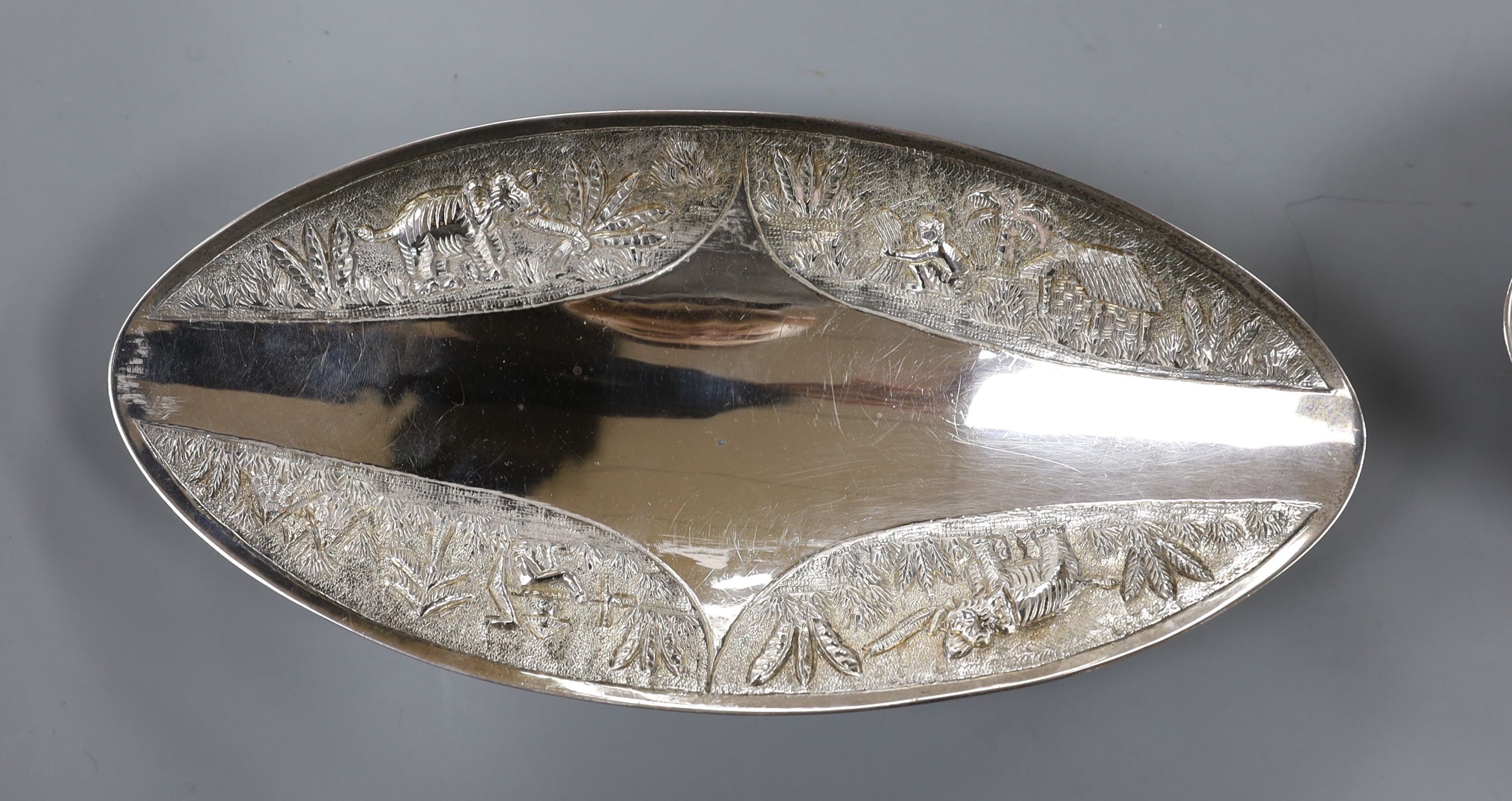 A pair of Indian sterling oval dishes, embossed with figures and elephants, 24.9cm, 18.5oz.